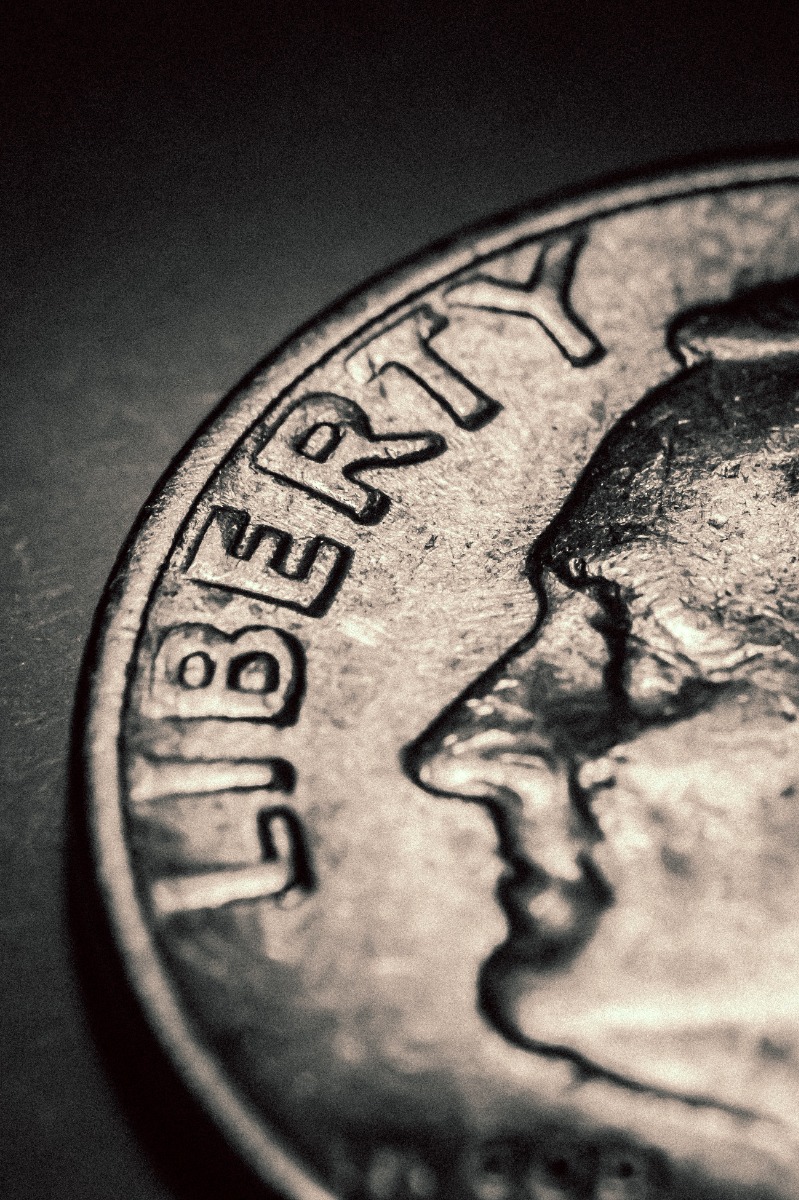 Closeup view of a Roosevelt dime on a black background.